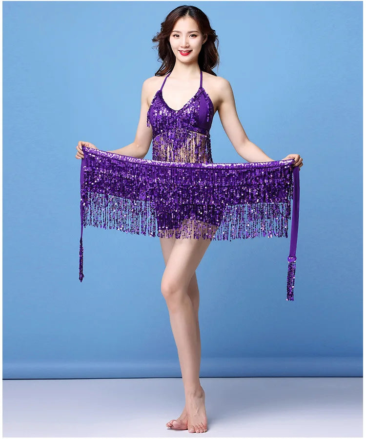 Woman in a shimmering purple fringe dance costume posing against a blue background
