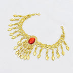 Gold anklet with hanging leaf charms and a central red gemstone on white background