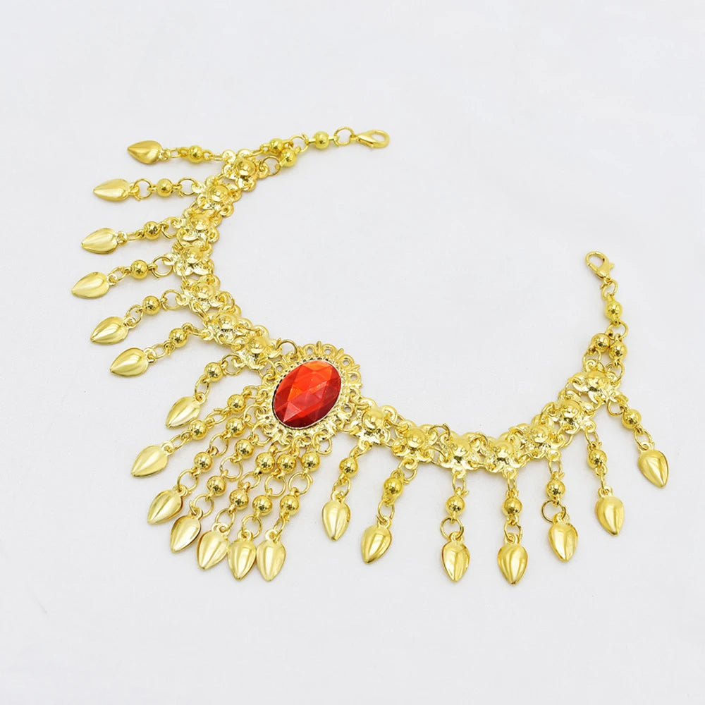 Gold anklet with hanging leaf charms and a central red gemstone on white background