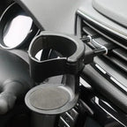Car air vent cup holder for drinks, mounted on dashboard interior, black plastic design