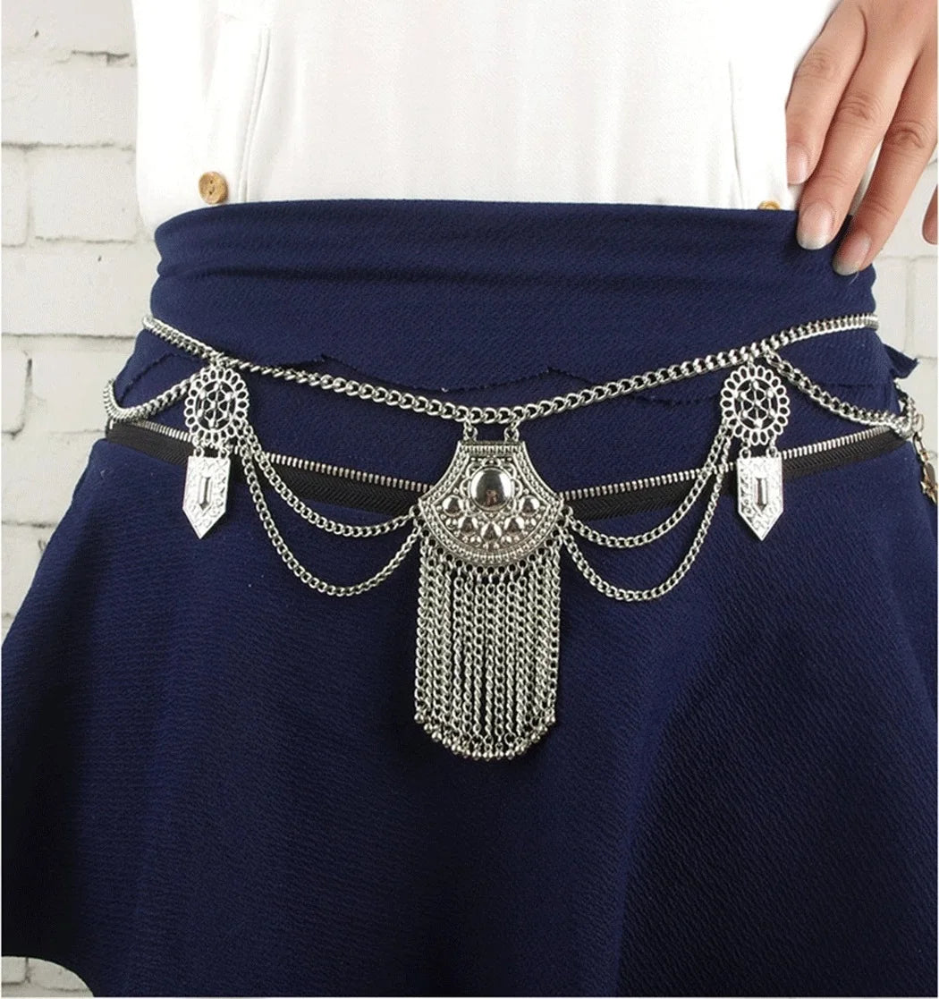 Silver chain tassel belt with ornate pendants on navy skirt and white top