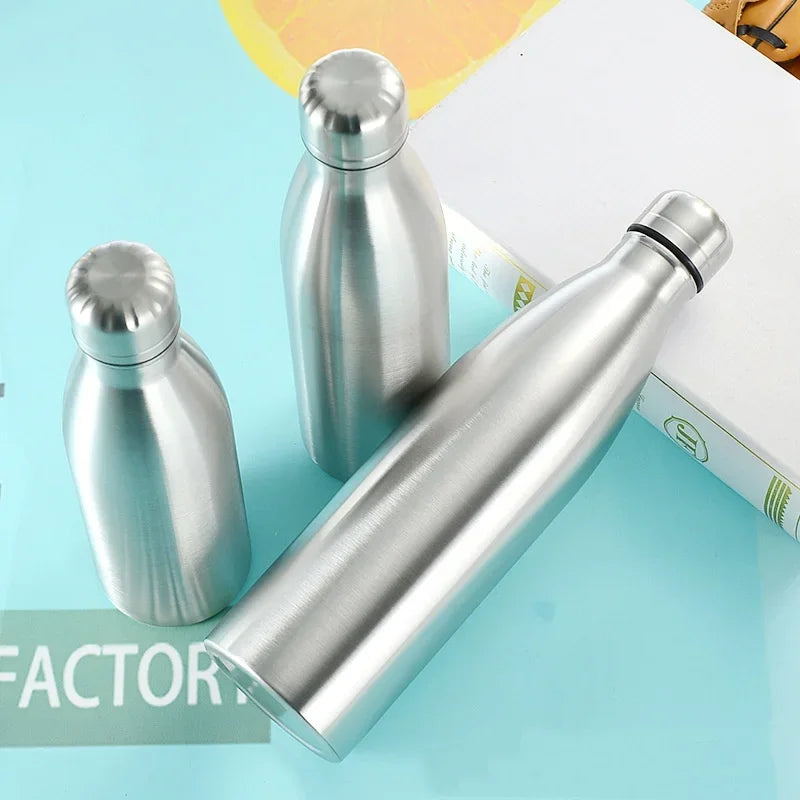 Stainless steel water bottles on blue surface, reusable insulated drinkware