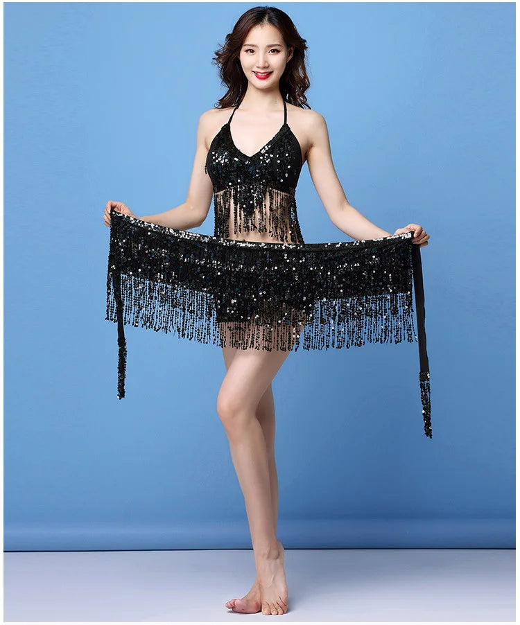 Woman wearing a black sequin fringe dance costume with a halter top and matching hip scarf