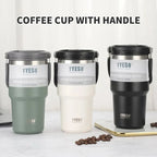Three TYESO vacuum insulated coffee cups with handles in green, white, and black on table