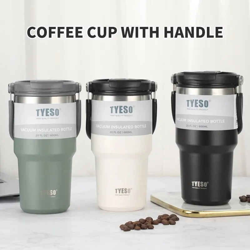 Three TYESO vacuum insulated coffee cups with handles in green, white, and black on table