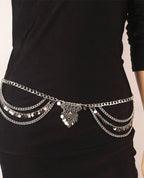 Silver layered chain belt with dangling coins on black dress, waist accessory detail