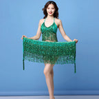 Woman wearing green sequin fringe dance costume against a plain blue background