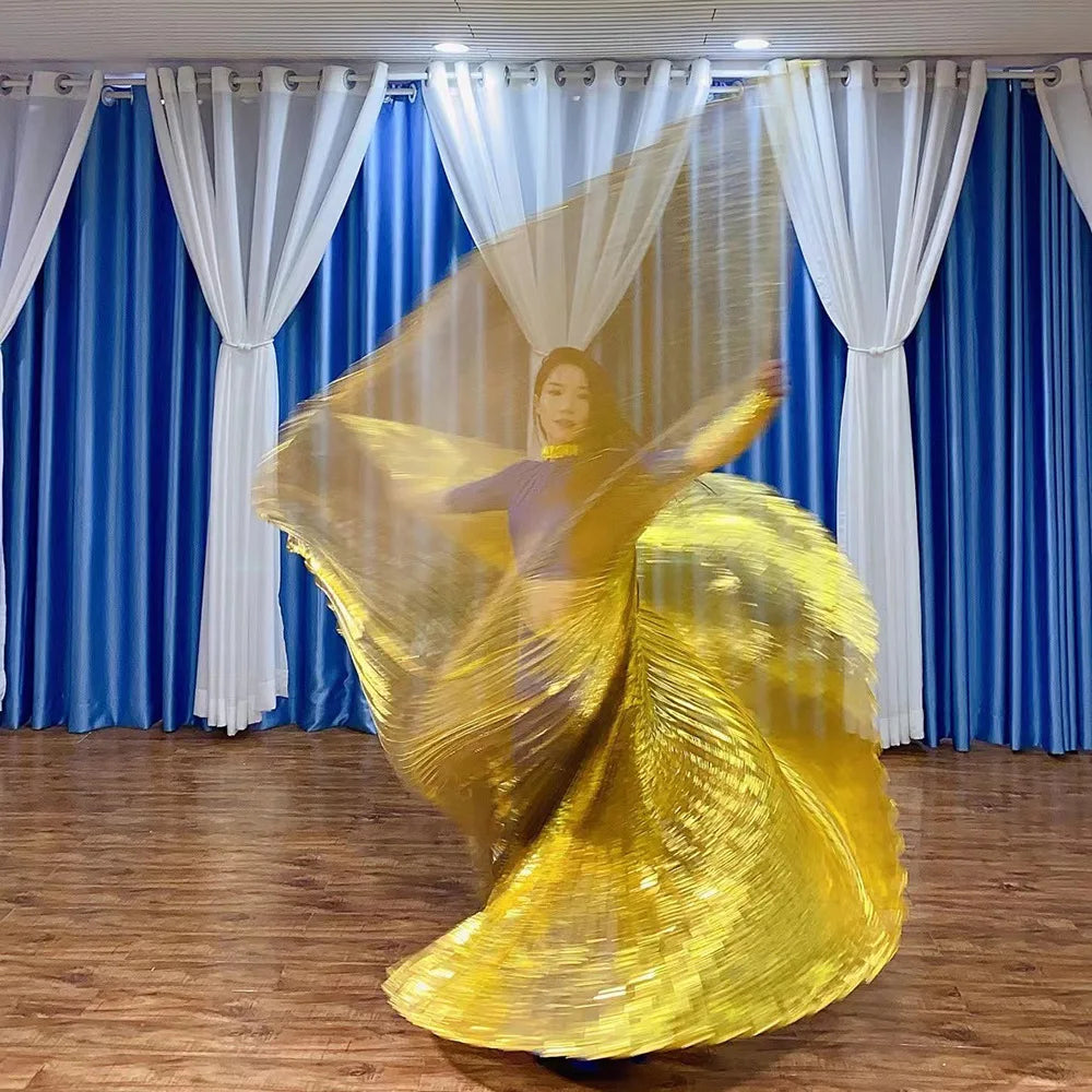 Woman dancing indoors with flowing gold wings, blue curtains and wood floor