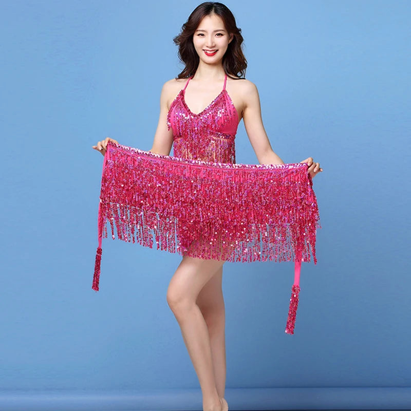 Woman in sparkly pink fringe dance dress posing against blue background