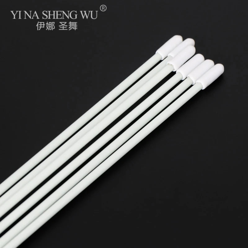 Set of white disposable swabs with plastic handles on a black background