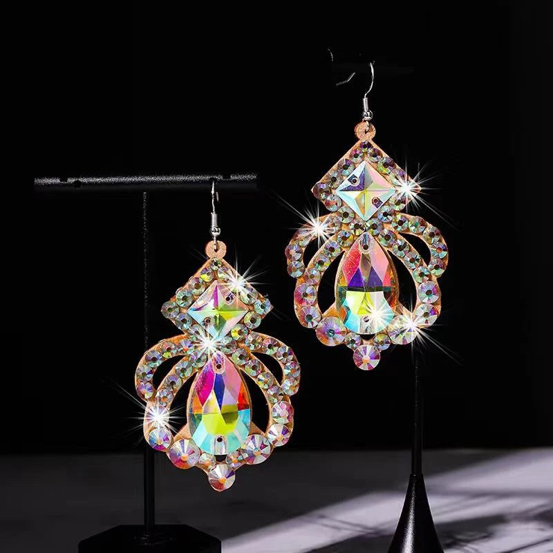 Iridescent crystal chandelier earrings with teardrop and geometric accents on black display