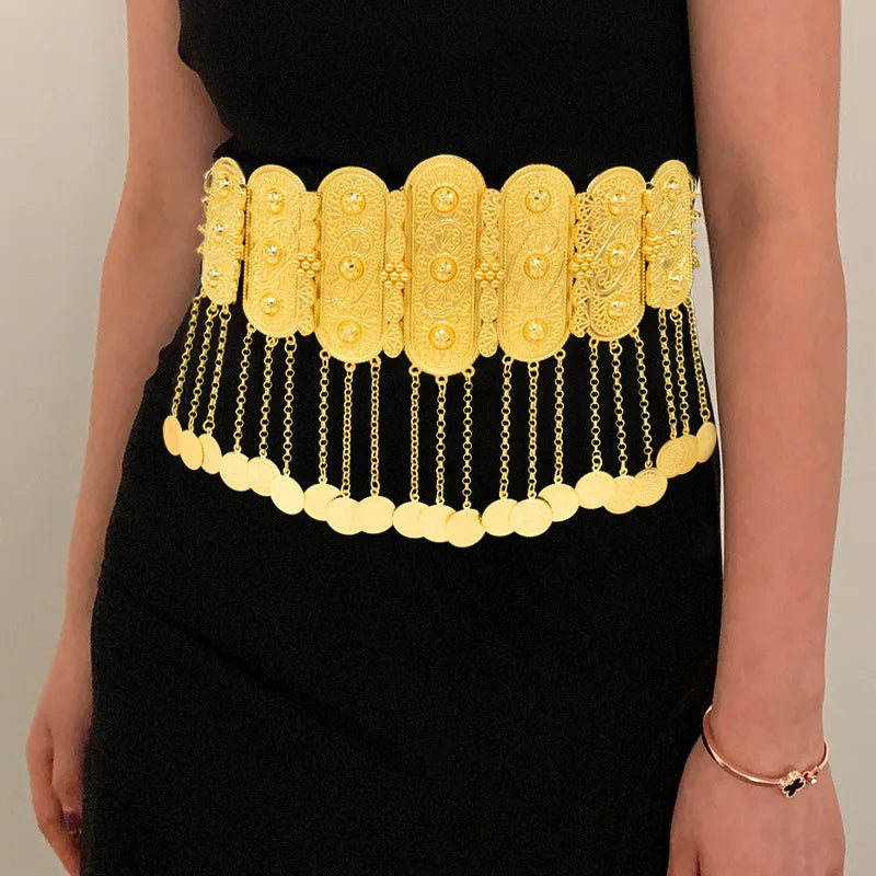 Gold statement waist belt with ornate design and hanging coin chains on black dress