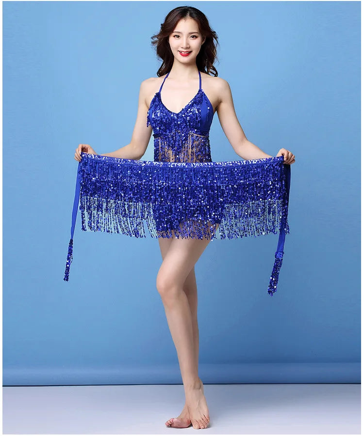 Woman modeling a blue sequined fringe dance costume on a blue background.