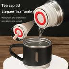 Thermos bottle pouring hot water into a black tea cup with push-button lid.