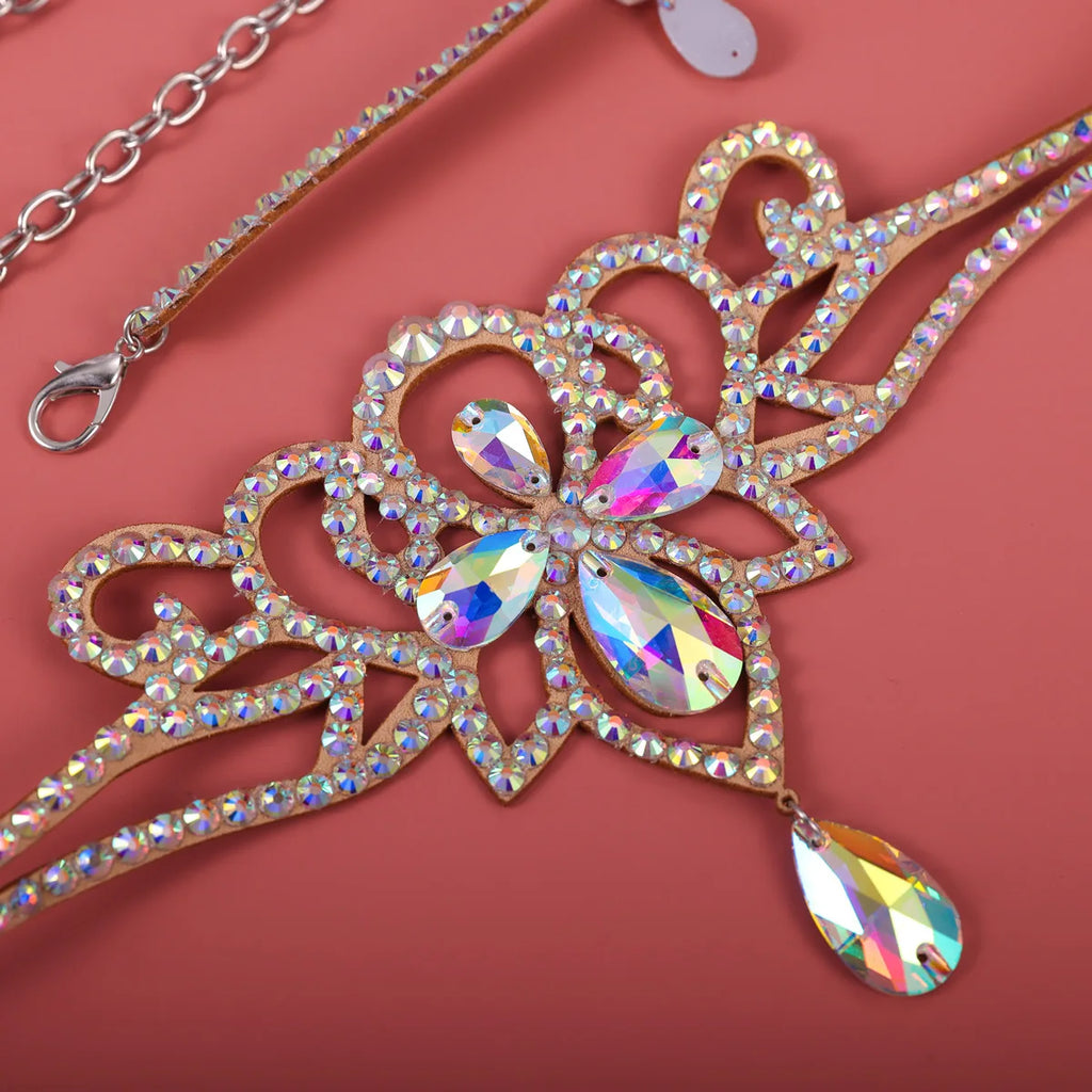Crystal rhinestone tiara headpiece with floral design and dangling teardrop gem on pink background