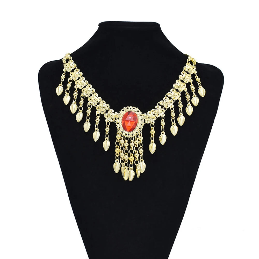 Gold statement necklace with red gemstone and dangling teardrop charms on black display