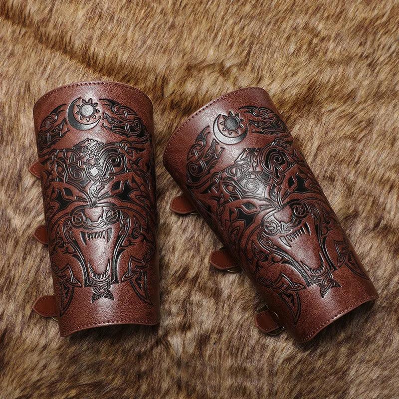 Pair of brown leather bracers with engraved wolf and Nordic designs on fur background