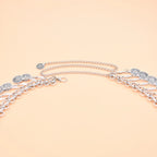 Silver chain belt with coin pendants on peach background