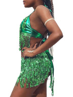 Woman wearing shiny green fringe sequin festival outfit with halter top and mini skirt