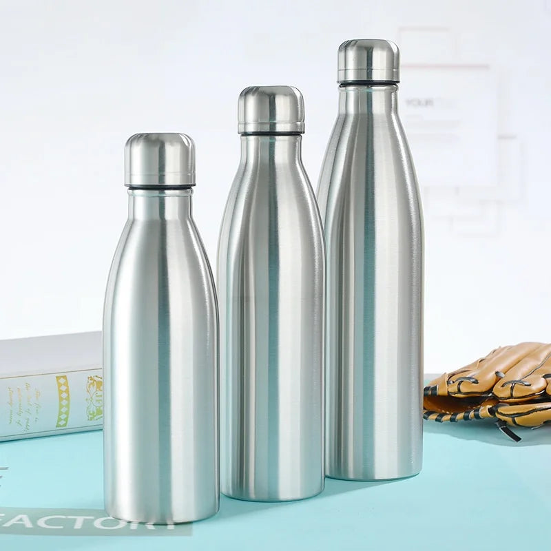 Three stainless steel insulated water bottles on a tabletop, minimalist design