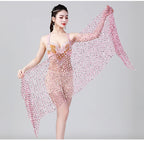 Woman modeling a sheer pink mesh shawl with sparkling details against a plain backdrop
