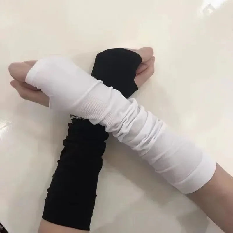Two arms wearing long fingerless gloves, one black and one white, on white background