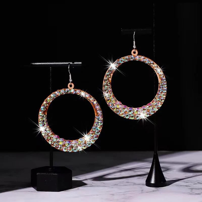 Sparkling round hoop earrings with multi-colored rhinestones on display stands