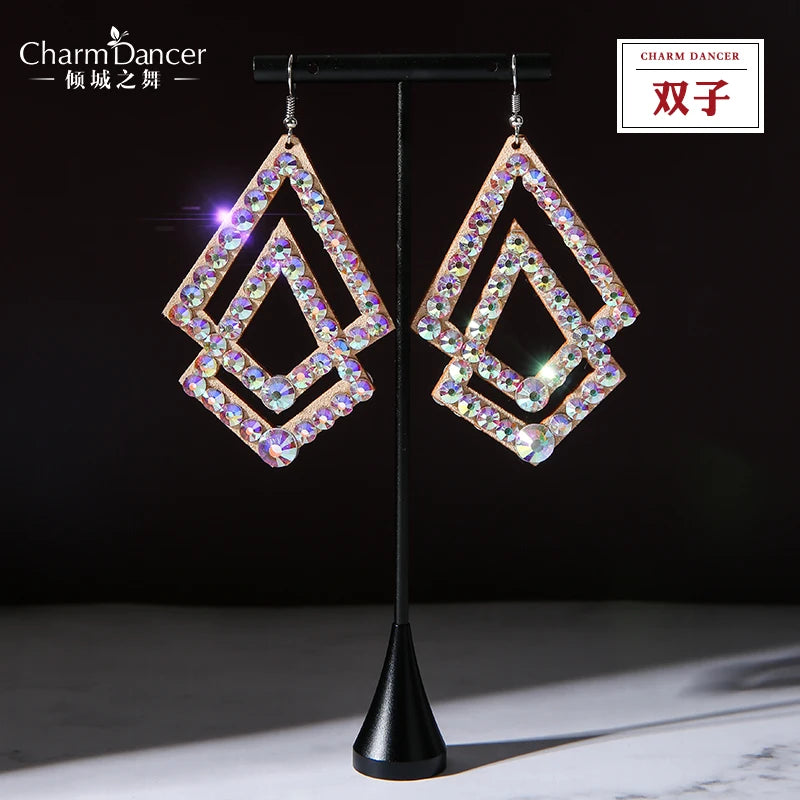 Pair of geometric rhinestone dangle earrings with gold-tone frames on a display stand