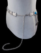 Silver boho waist chain belt with decorative links and turquoise accent on mannequin