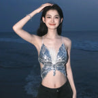 Woman in sequin butterfly crop top posing on the beach at dusk