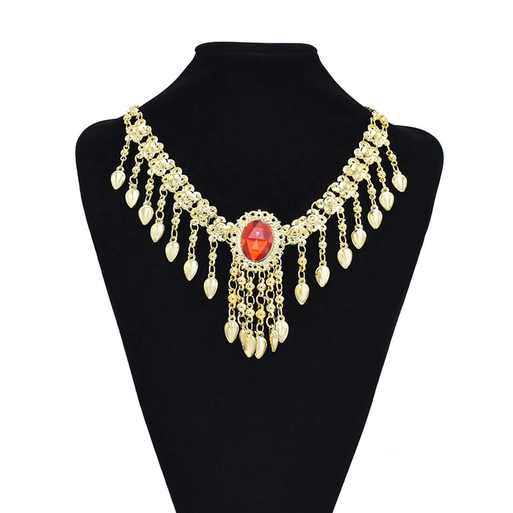 Gold statement necklace with red gemstone centerpiece and hanging teardrop charms on display stand