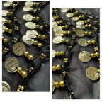 Close-up of gold coin beads and black thread on fabric, decorative accessory detail