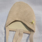 Beige suede baby bonnet with chin straps and small gold animal embroidery on the side