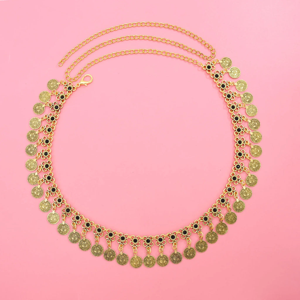 Gold coin statement necklace with black floral accents on a pink background