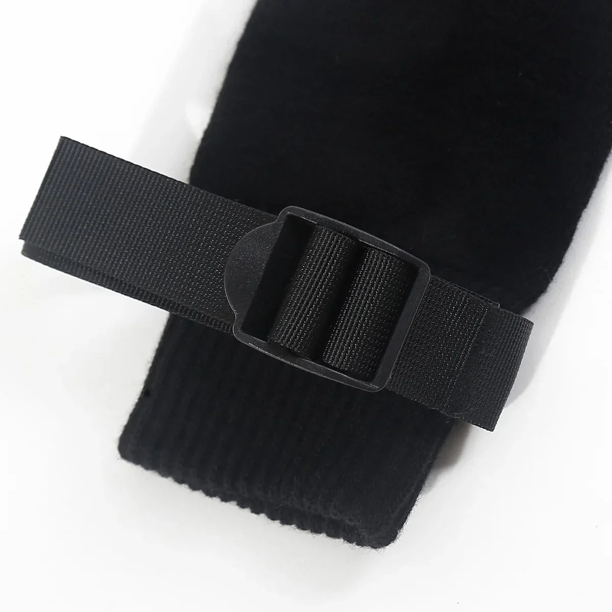 Adjustable black strap with buckle detail on a black fabric sleeve, closeup view