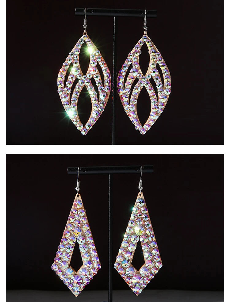 Hanging sparkly rhinestone dangle earrings in leaf and diamond shapes on black display