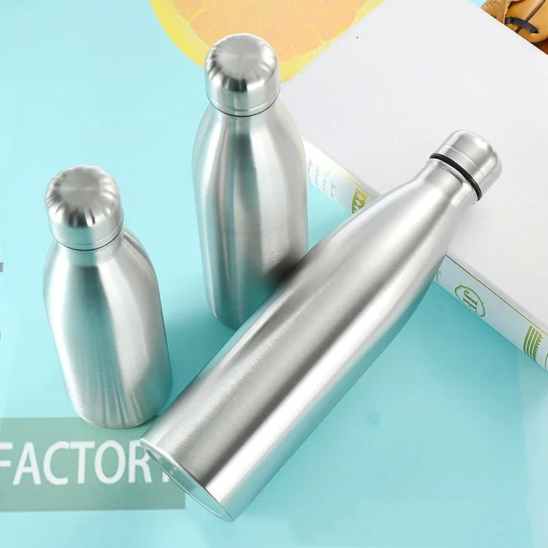 Three stainless steel water bottles on a blue surface, reusable and eco-friendly drinkware