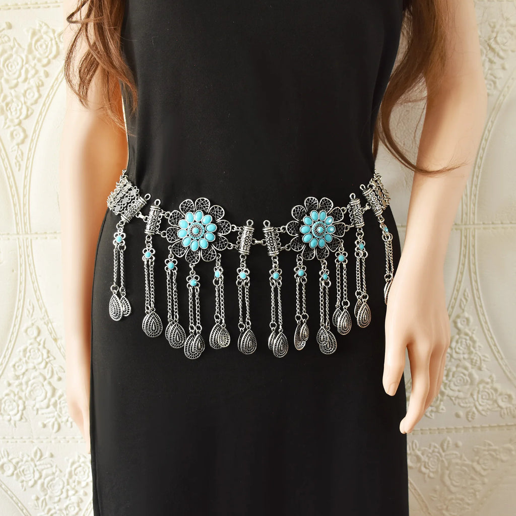 Boho silver waist chain belt with turquoise floral accents and dangling charms on black dress