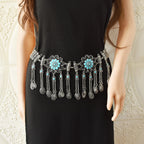 Boho silver waist chain belt with turquoise floral accents and dangling charms on black dress