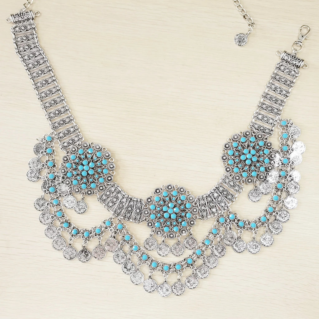 Bohemian silver necklace with turquoise accents and coin charms on light background
