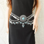 Boho silver hip belt with turquoise accents and dangling coins on woman in black dress