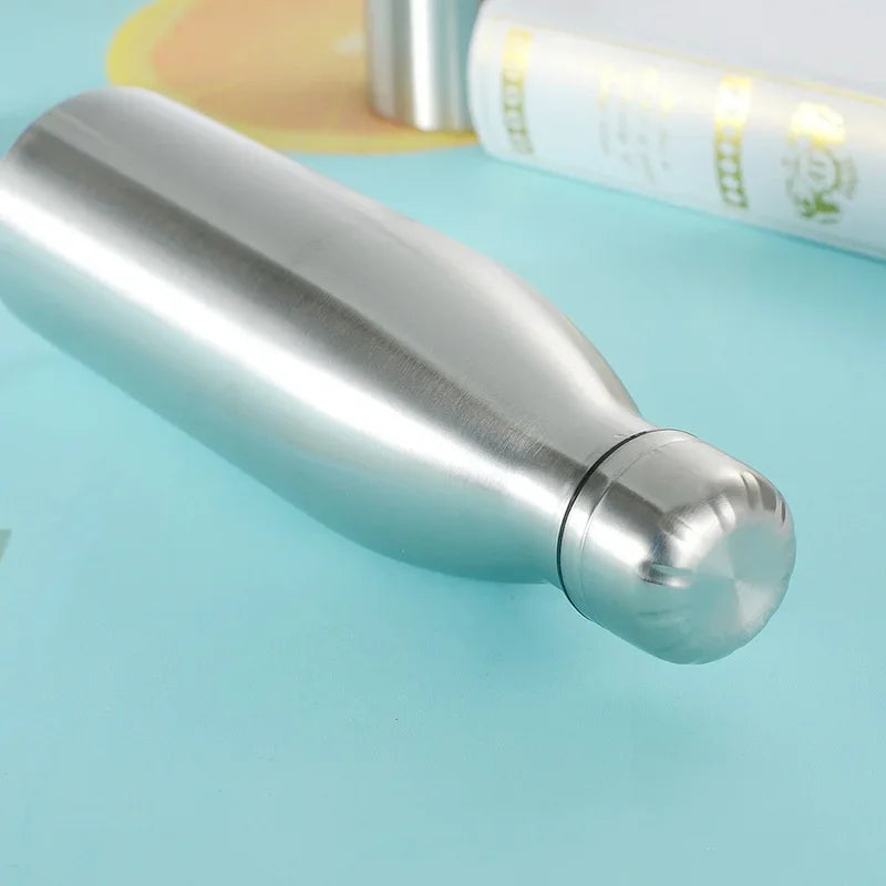 Stainless steel insulated water bottle on a light blue surface