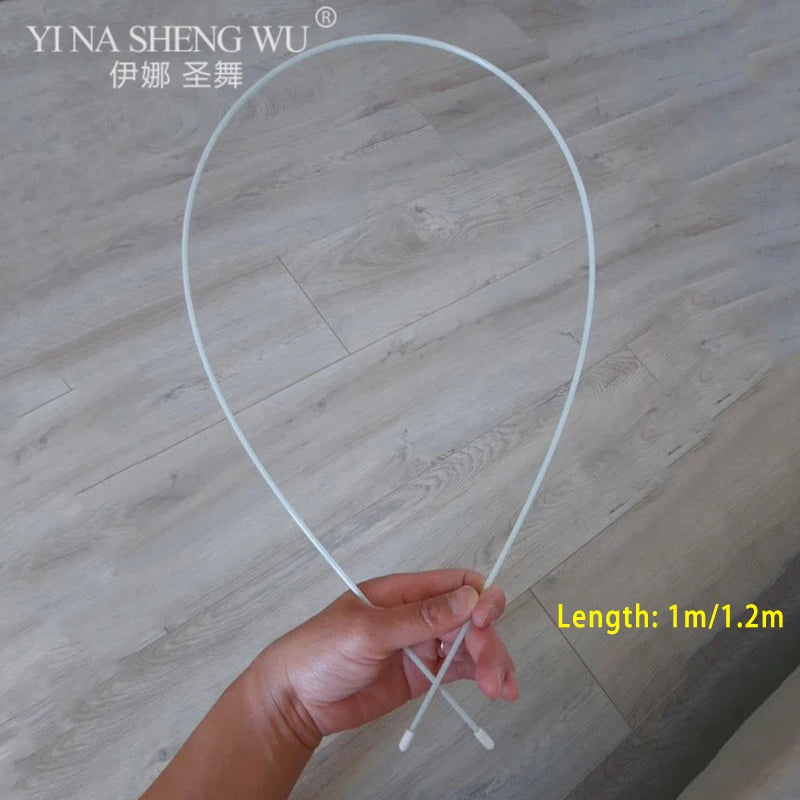 Hand holding white flexible rod, 1m to 1.2m length, on wood floor background.