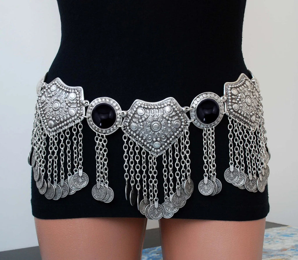 Ornate silver coin belt with dangling chains and black stones worn on a black dress