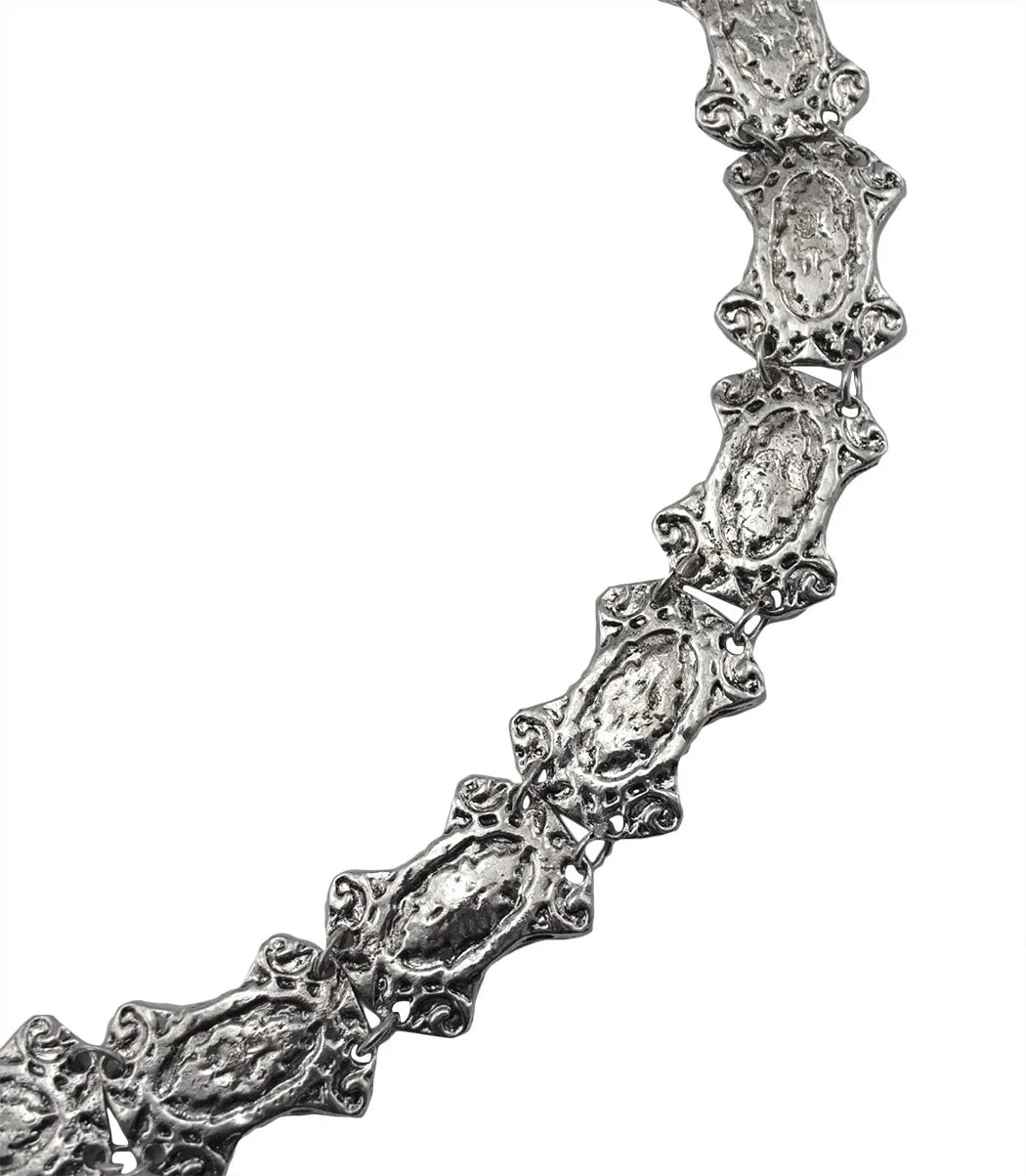 Textured silver necklace with ornate, linked oval segments on a white background