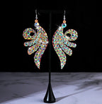 Colorful rhinestone angel wing earrings on black display stand, sparkling, fashion jewelry