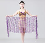 Woman in gold and purple belly dance costume holding a purple sequin shawl, studio background