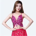 Woman wearing sparkly pink butterfly sequin crop top and matching skirt with coin accents